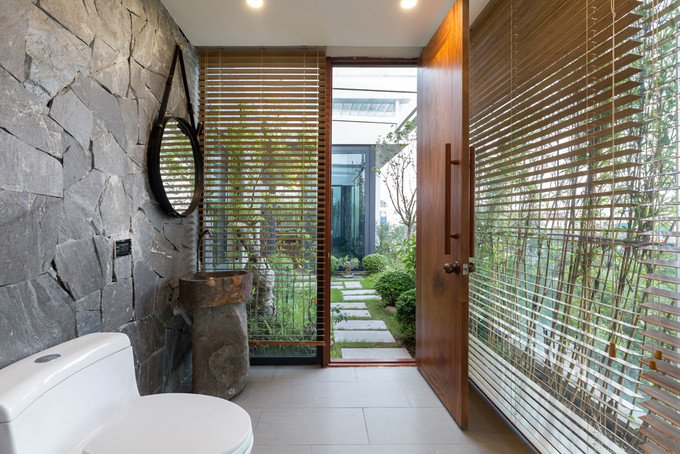 Nhà vệ sinh thông thoáng nhưng vẫn kín đáo nhờ cửa chớp lật và rặng trúc che bên ngoài