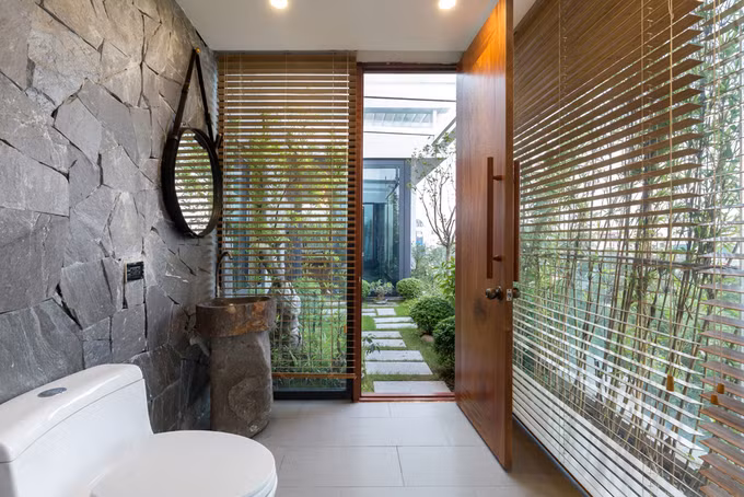 Nhà vệ sinh thông thoáng nhưng vẫn kín đáo nhờ cửa chớp lật và rặng trúc che bên ngoài