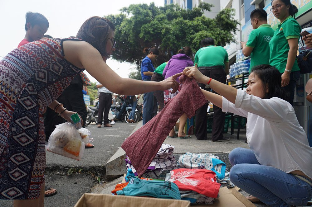 Một người dân đang chọn chiếc áo để mặc tạm do căn hộ của chị vẫn đang bị phong tỏa.