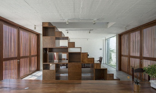 Cầu thang vừa là tủ lưu trữ đồ vừa là vách ngăn chắn phòng khách và nhà bếp.