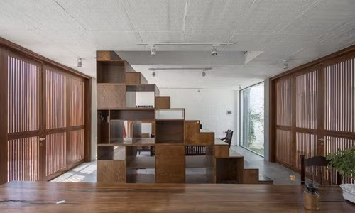 Cầu thang vừa là tủ lưu trữ đồ vừa là vách ngăn chắn phòng khách và nhà bếp.