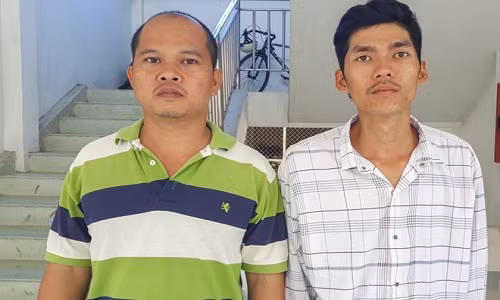 Vương (trái) và phát tại cơ quan điều tra.