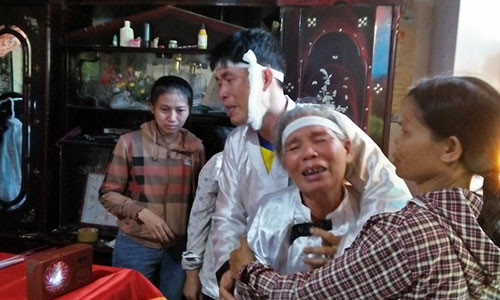 Anh Hoàng và mẹ chết lặng trước quan tài của vợ. Ảnh: H.Thạch.