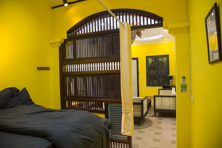 Cũng như phòng khách, không gian phòng ngủ nổi bật với mảng tường vàng ươm.