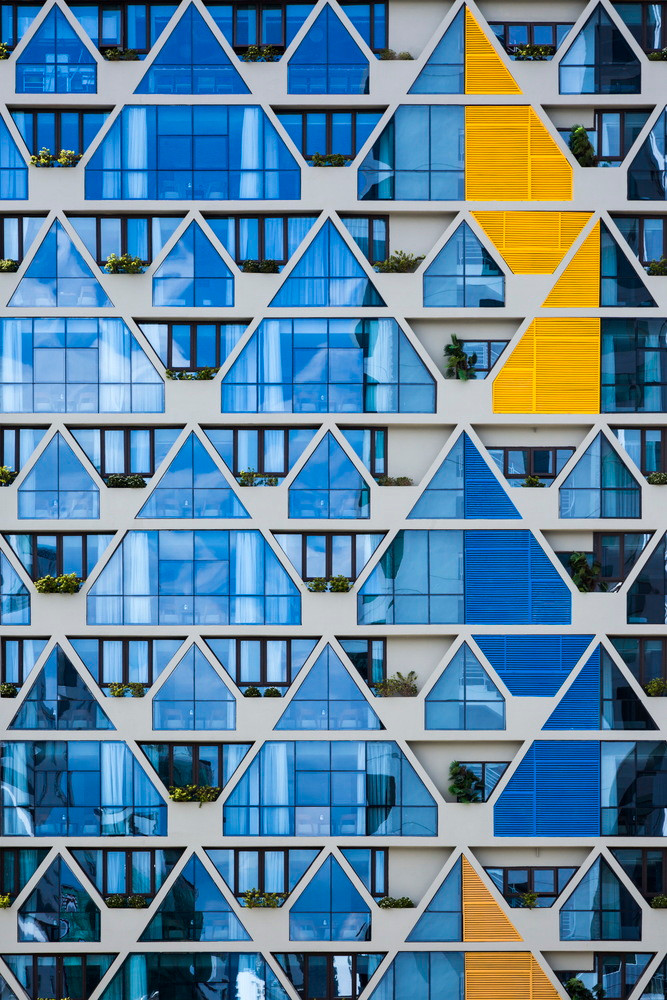 Những ô cửa kính đơn điệu biến thành bức tường đầy màu sắc.