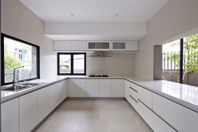 Nhà bếp thoáng đãng với thiết kế cửa sổ kính lớn kết hợp sắc trắng tinh khôi.