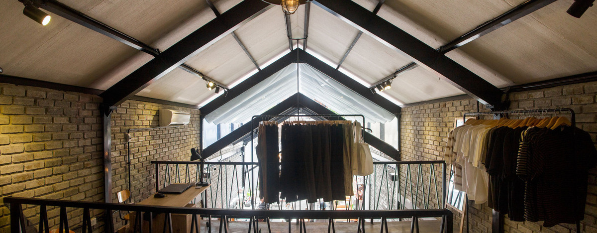 Trên gác lửng là không gian dành cho thời trang hand-made kết hợp bàn cà phê. 