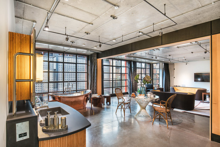 Trần bê tông thô và các đường ống đồng để lộ mang dấu ấn của thiết kế máy móc.