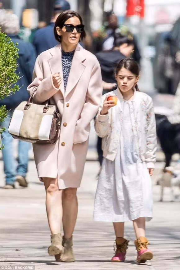 Theo quan sát, con gái Tom Cruise mặc đầm kẻ sọc kết hợp áo khoác họa tiết hoa bên ngoài và đi boots cổ thấp.