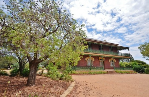 Bên ngoài ngôi biệt thự là khoảng sân rộng có cây lớn tỏa bóng mát.