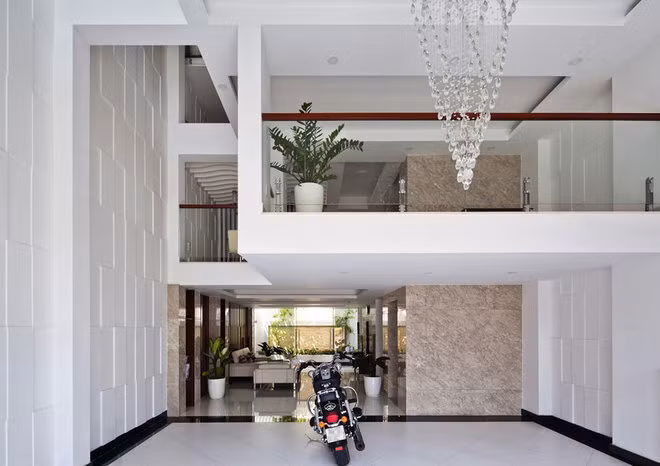 Khi thiết kế nhà ống 3 tầng, kiến trúc sư chừa khoảng sân để xe rộng phía trước và sân sau 2m.