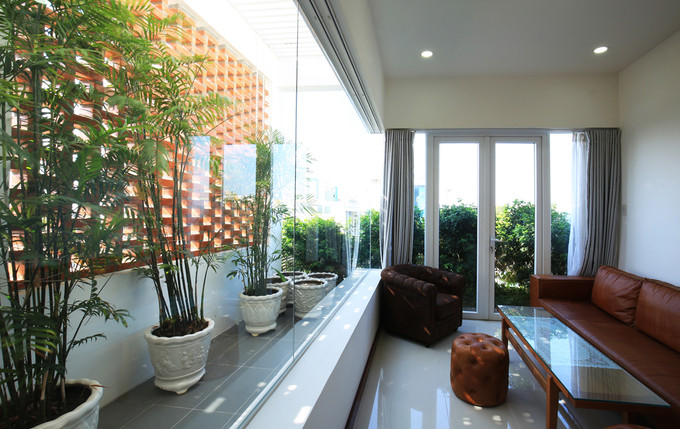 Sân thượng được thiết kế thành khu vực thư giãn. Bức tường gạch nung gợi nhớ kiến trúc truyền thống.