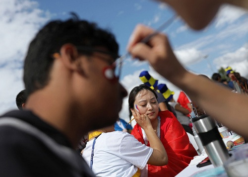 Vẽ quốc kỳ lên mặt cho cổ động viên cũng là công việc hốt bạc trên đường phố ở Nga. Chỉ khoảng 100 rúp (khoảng 37.000), người hâm mộ sở hữu ngay một lá cờ tổ quốc ở bất kỳ vị trí nào. Ảnh: Sputnik.