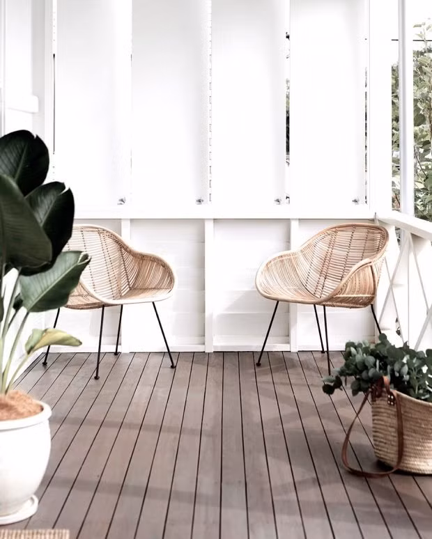 Nếu muốn tối giản mọi thứ và tạo không gian vùng nhiệt đới thì bạn có thể sơn màu trắng cho bức tường gỗ xung quanh cùng vài chậu cây đơn giản cùng những chiếc ghế mây thanh lịch này.