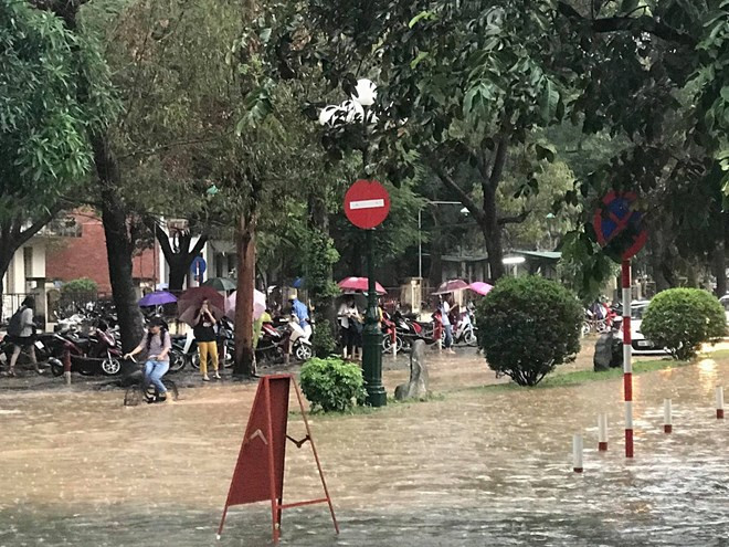 Mưa lớn đúng giờ tan tầm khiến nhiều phương tiện phải ra về trong tình trạng khổ sở. (Ảnh: PV/Vietnam+)