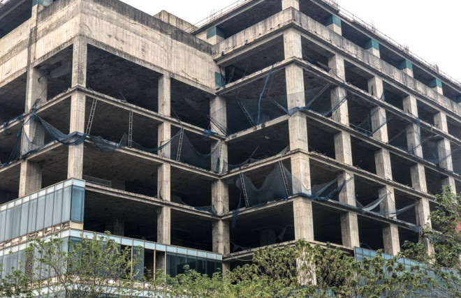 Xung quanh dự án cỏ mọc um tùm, nhiều cọc sắt đã hoen gỉ. Ảnh: Tổ quốc.