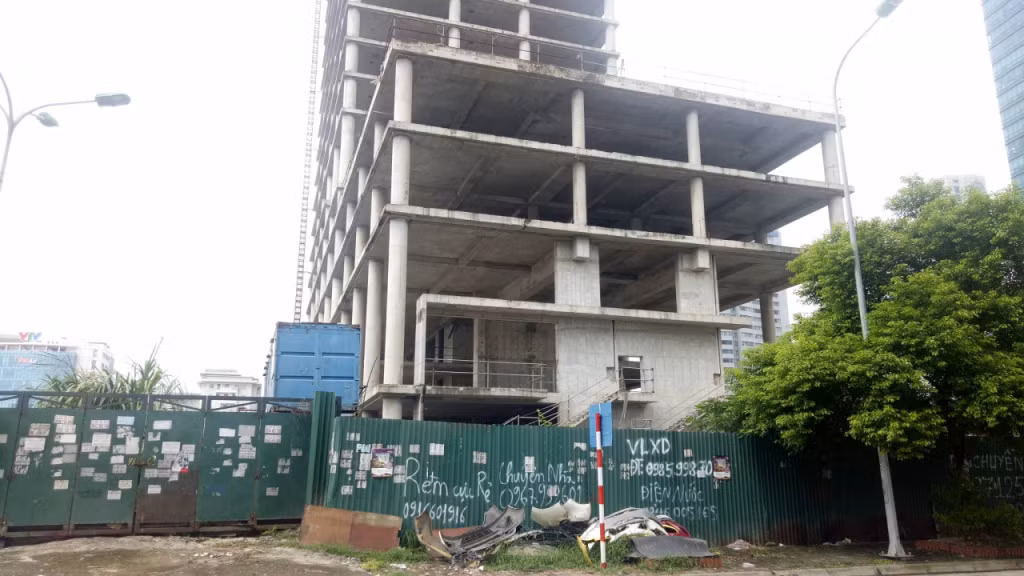 Được khởi công từ năm 2011 và dự kiến hoàn thành sau 3 năm, nhưng đến tháng 8/2018, dự án Vicem Tower trên trục đường vành đai 3 Phạm Hùng, cạnh tòa nhà Keangnam thuộc lô đất 10E6 Khu đô thị mới Cầu Giấy (Hà Nội), mới chỉ xong phần xây thô. Ảnh: SKCĐ.