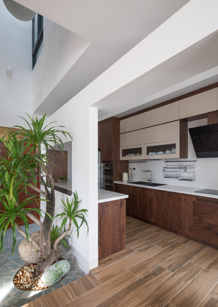 Phòng bếp được thiết kế mở với một khoảng không ngập ánh nắng và cây xanh.