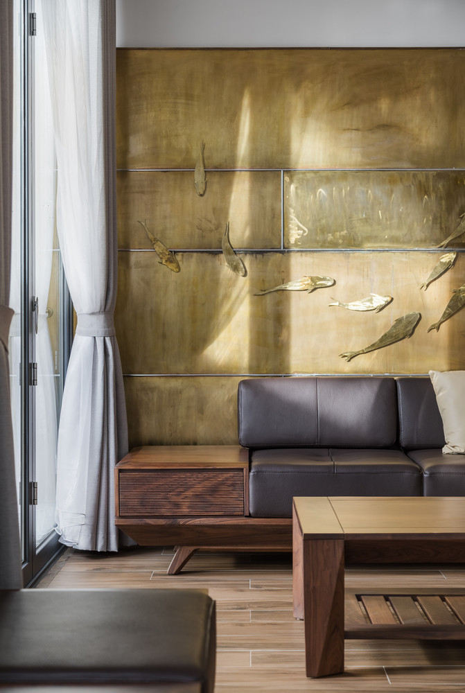 Mảng tường ốp với họa tiết đàn cá là điểm nhấn tại khu vực tiếp khách.