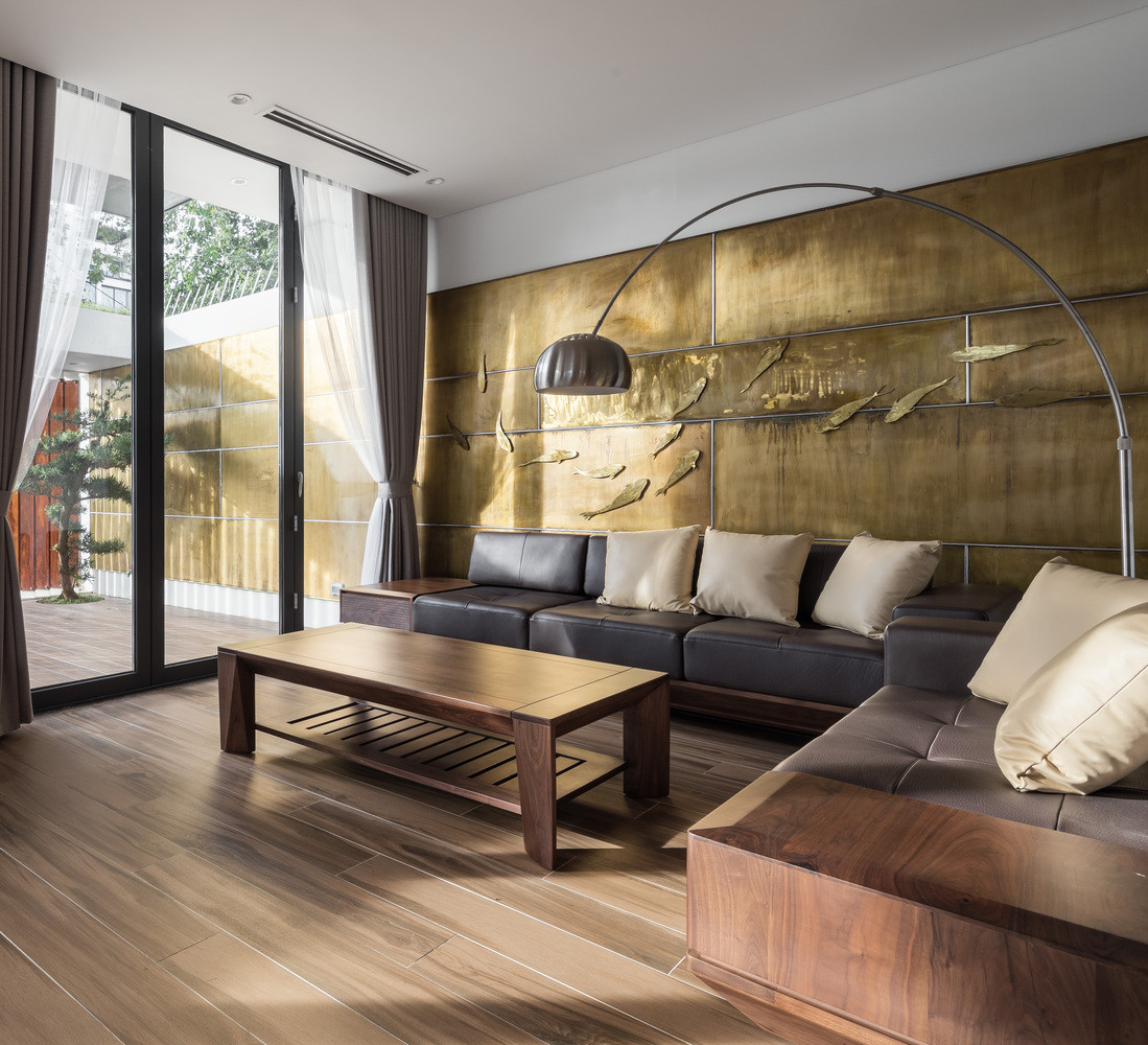 Phòng khách thoáng sáng với sofa gỗ kê sát tường.