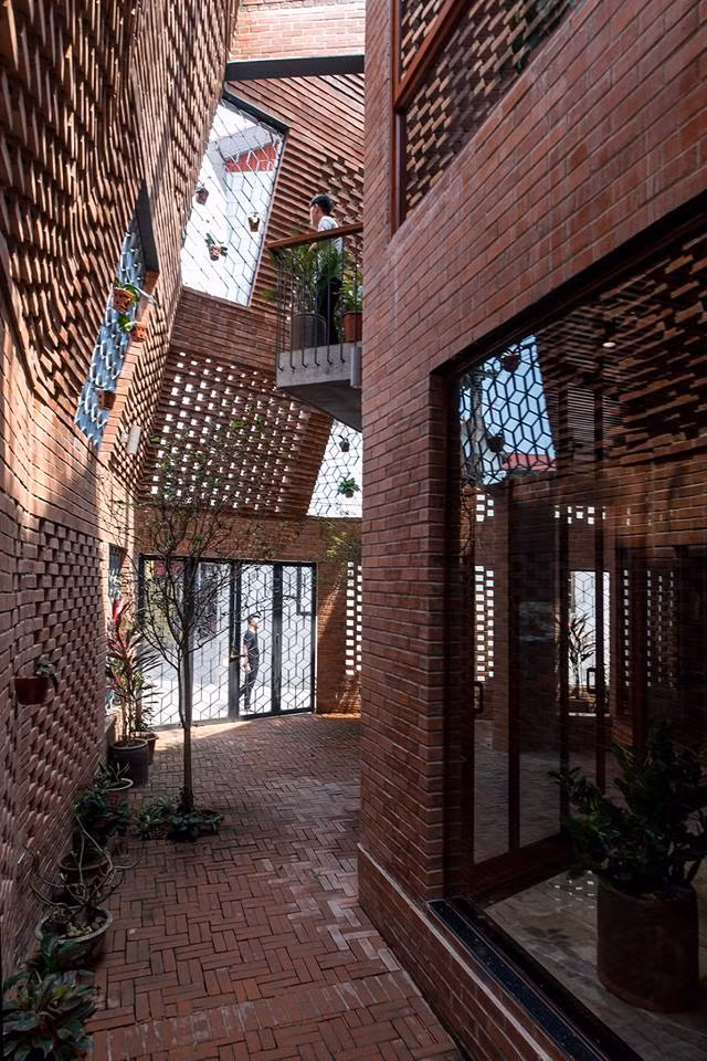 Độc đáo hơn cả, ngôi nhà gạch thô còn được bảo vệ bằng một lớp tường gạch cao, thoáng ở bên ngoài.