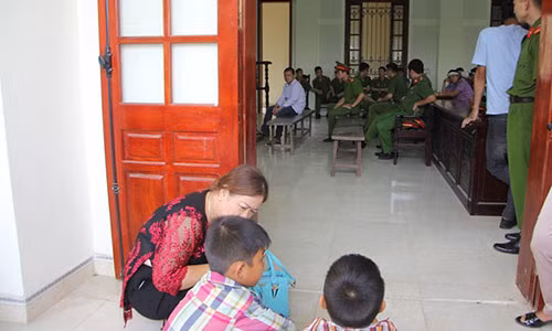 Những người con của bị cáo ngồi ngoài nhìn vào.