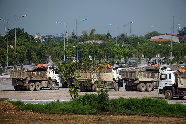 Hàng chục máy móc chuyên dụng và nhiều xe tải lớn làm việc liên tục, gấp rút.