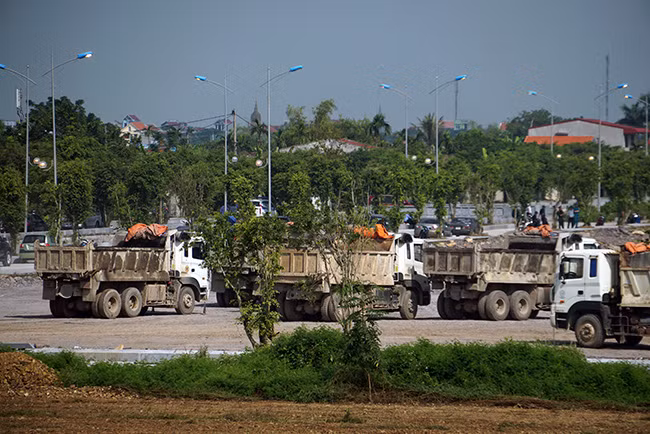 Hàng chục máy móc chuyên dụng và nhiều xe tải lớn làm việc liên tục, gấp rút.