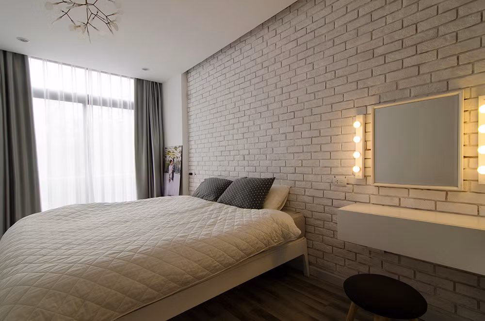 Phòng ngủ ấm áp, thân thuộc với tường gạch trần.