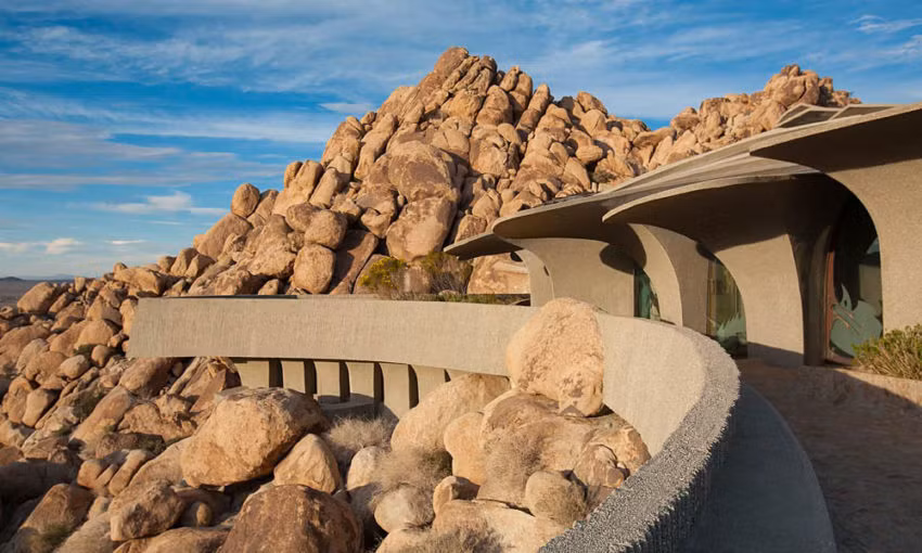 Bên ngoài là bức tường gồ ghề, hài hòa với phong cảnh có đá bao bọc xung quanh.