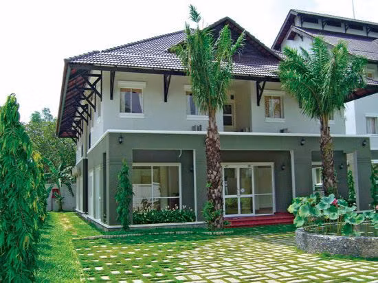 Mẫu nhà 2 tầng mái thái có sân rộng và không gian xanh tươi nổi bật. Ảnh: Nhabinhduong.