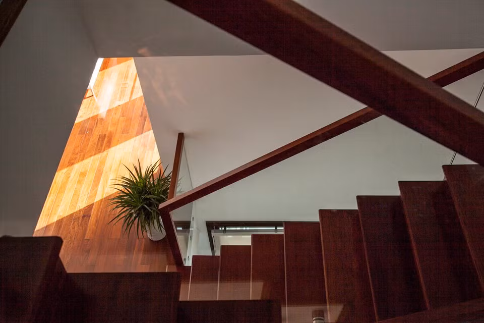 Cầu thang gỗ lan can kính vừa mộc mạc vừa hiện đại.