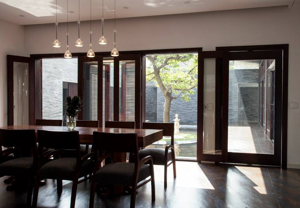 Phòng ăn dưới tầng 1 có tầm nhìn hướng ra khoảng sân trong với hồ nước, cây xanh.