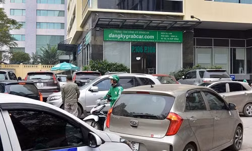 Rất đông đối tác đã tập trung trước cửa tòa nhà Kim Ánh, nơi có văn phòng tại Hà Nội của Grab, để tiếp tục phản đối việc Grab đơn phương tăng chiết khấu. Ảnh: Việt Hùng.