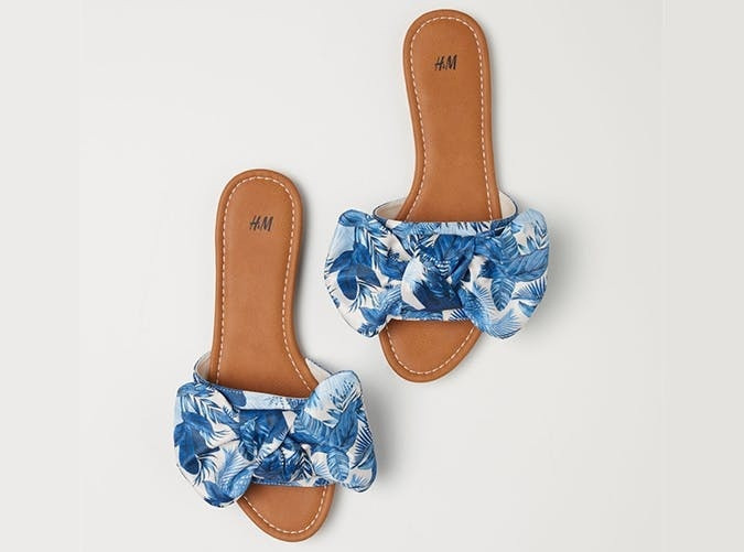 Dép lê nơ hoa tôn lên vẻ nữ tính, điệu đà cho chị em. Bạn có thể kết hợp đôi dép xinh xắn này với quần short hay váy đều phù hợp