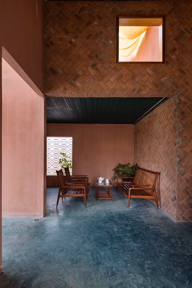 Nền xi măng, tường gạch thô và bộ bàn ghế cũ gợi vẻ mộc mạc cho ngôi nhà.