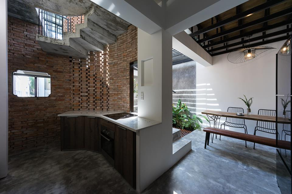 Tủ bếp thiết kế uốn theo bức tường gạch mộc.