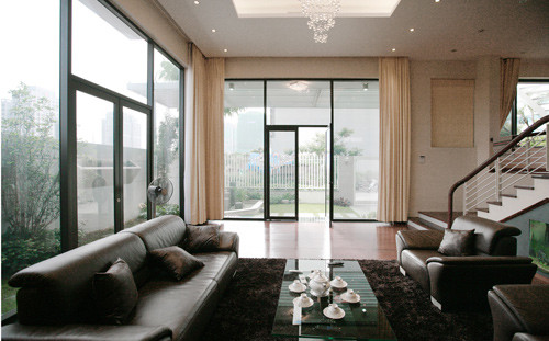 Phòng khách với hệ thống tường kính bao quanh tạo sự thông thoáng.