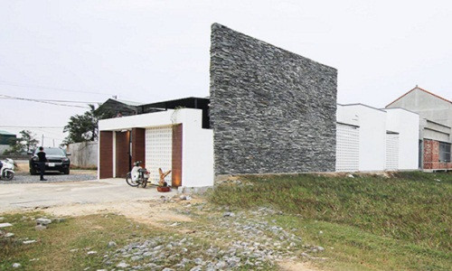 Nhìn từ xa, ngôi nhà 1 tầng của anh Tài và chị Quỳnh nổi bật nhờ lối kiến trúc phá cách với tông màu trắng đen.