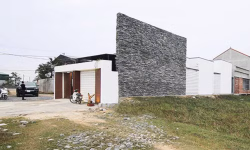 Nhìn từ xa, ngôi nhà 1 tầng của anh Tài và chị Quỳnh nổi bật nhờ lối kiến trúc phá cách với tông màu trắng đen.