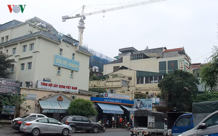 Theo quy định, khoảng cách an toàn giữa các cửa hàng xăng dầu với các công trình công cộng xung quanh phải bảo đảm 50m, cách đường điện cao thế 1,5 lần chiều cao cột điện và cách các điểm có tính chất nguy hiểm, cháy nổ 100m. Một cửa hàng xăng trên đường Đê La Thành "nằm gọn" trong khu dân cư, xung quanh còn đang xây dựng những tòa nhà lớn.