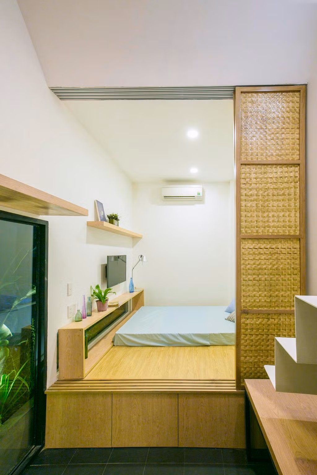 Phòng ngủ độc đáo với cửa trượt bằng tre linh hoạt. Nguồn ảnh: Archdaily.