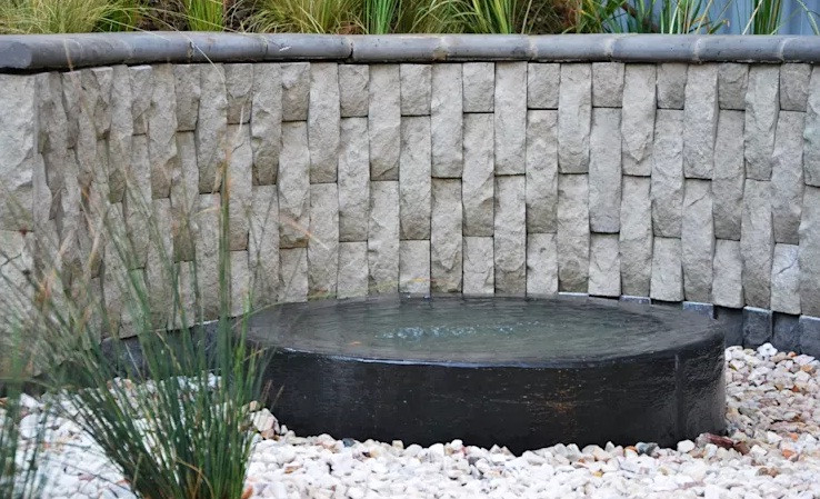 Bạn có thể thả cá cảnh và nuôi cây thủy sinh mini ở hồ nước trong chậu đá. Ảnh: Homify.