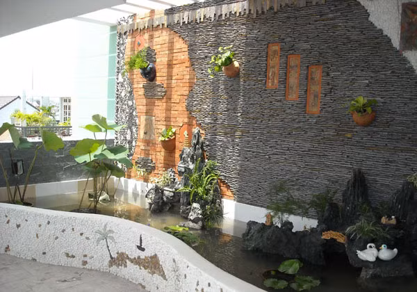 Dòng nước chảy trên tường cùng ánh sáng chiếu xuống trực tiếp làm cho không gian mát mẻ hơn. Ảnh: Canhquanzions.