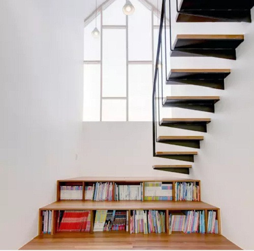 Cầu thang kết hợp giá sách tiết kiệm không gian. Ảnh: Mlnp Architects.
