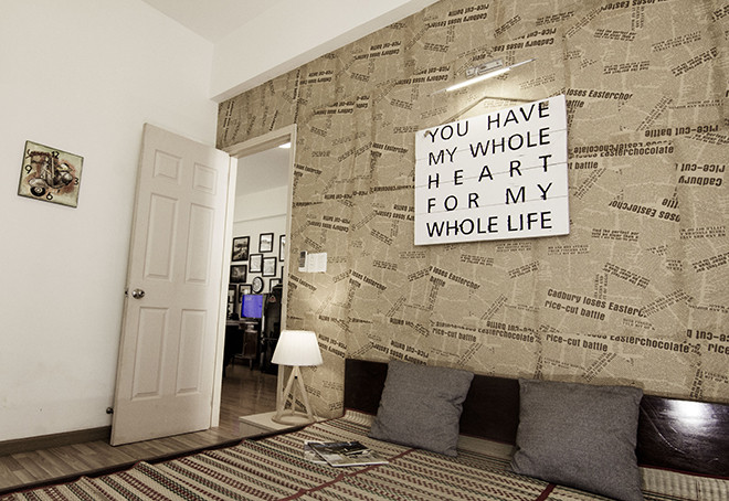 Bức tường đầu giường được trang trí bằng các thanh ván pallet ghép lại với nhau và dán chữ. Nguồn ảnh: Cát Mộc.