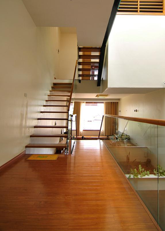 Cầu thang gỗ lan can kính mang đến vẻ đẹp hiện đại cho ngôi nhà ống 4 tầng.