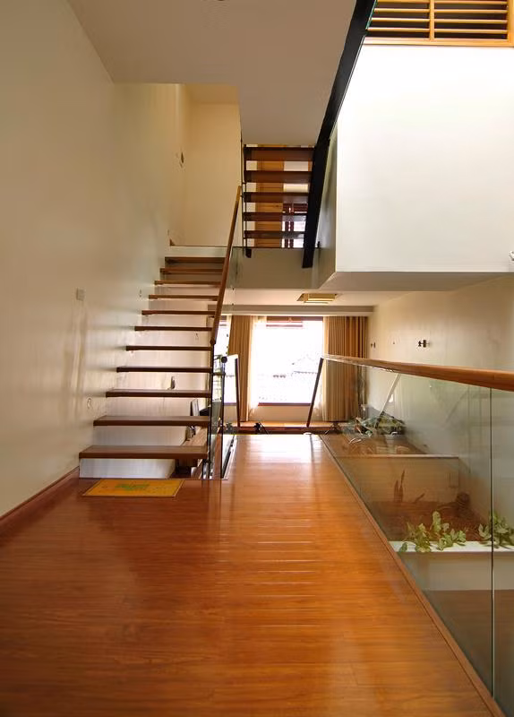 Cầu thang gỗ lan can kính mang đến vẻ đẹp hiện đại cho ngôi nhà ống 4 tầng.
