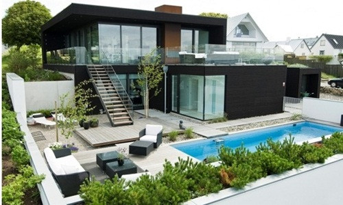 Biệt thự biển hiện đại nổi bật với màu đen bắt mắt kết hợp bức tường màu xanh lá cây. Ảnh: Archdaily.