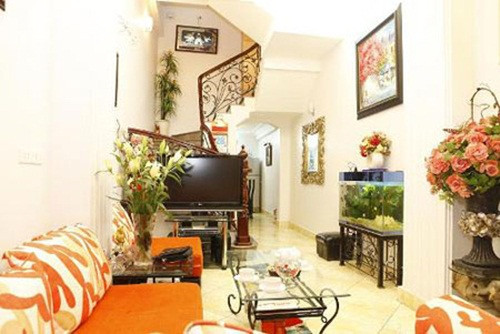 Phòng khách nổi bật với bộ sofa màu cam. Ảnh: Khám phá.